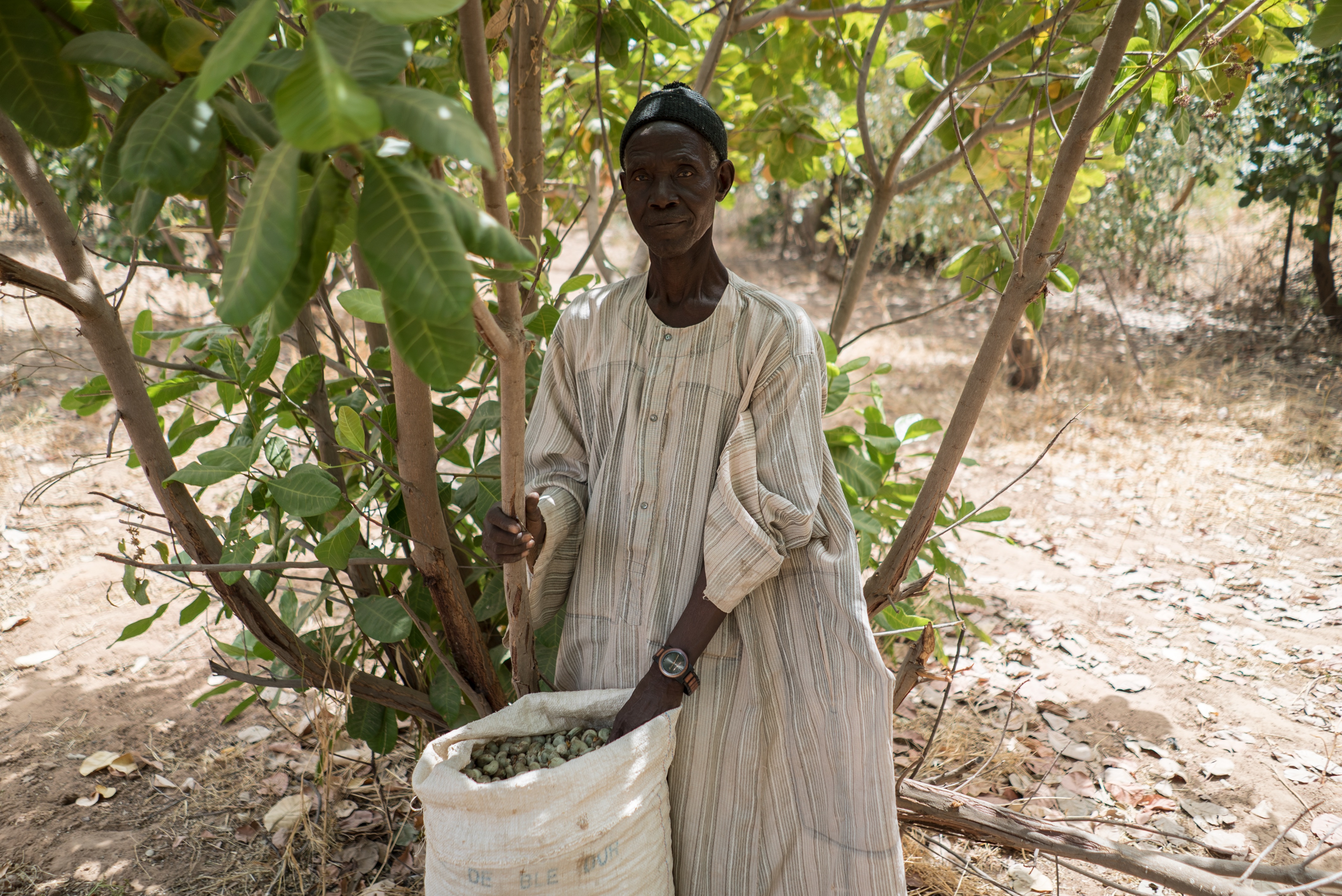 Keba standing with a sack full of cashews