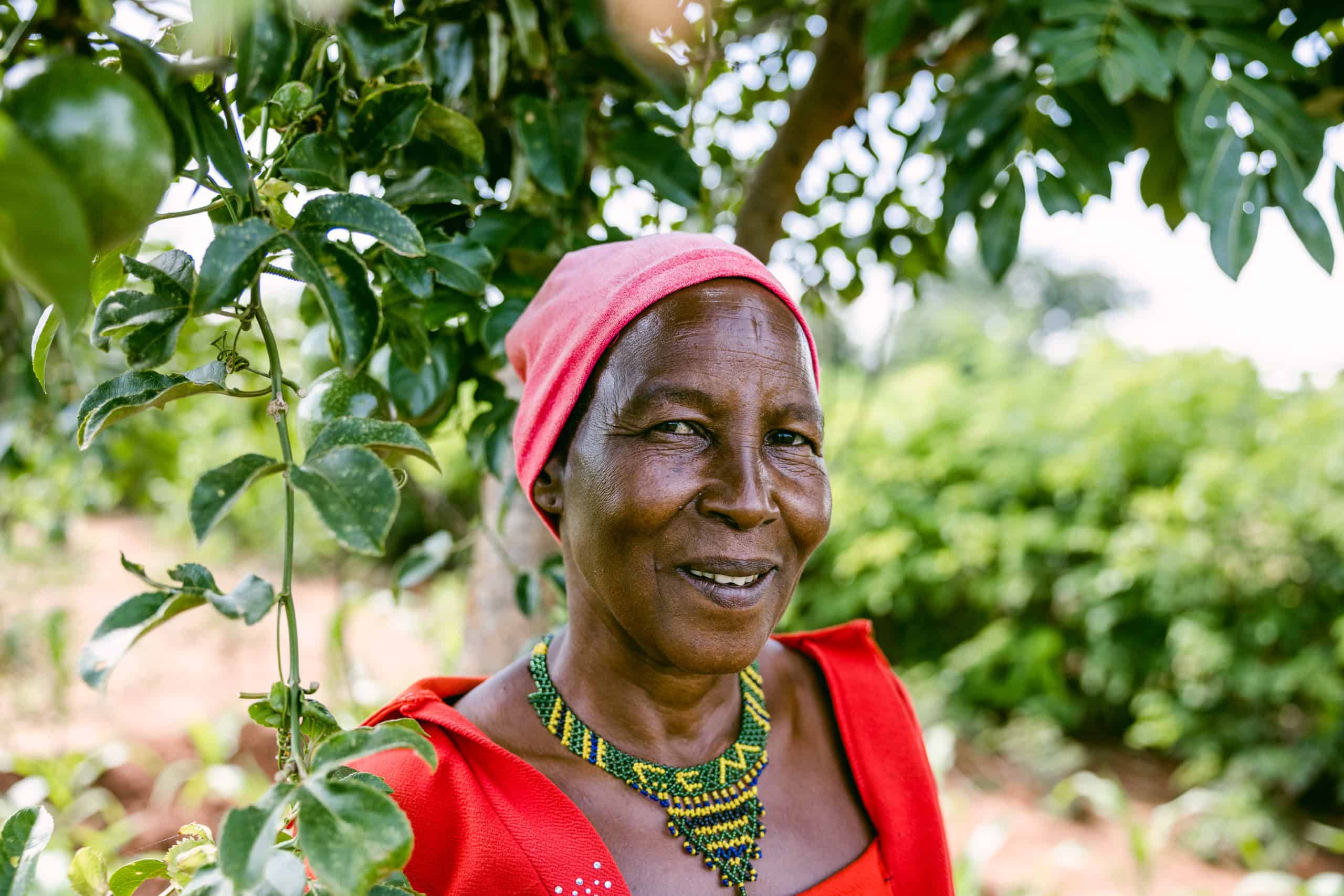 Mariam Lyimo Sunta standing under a fruit tree