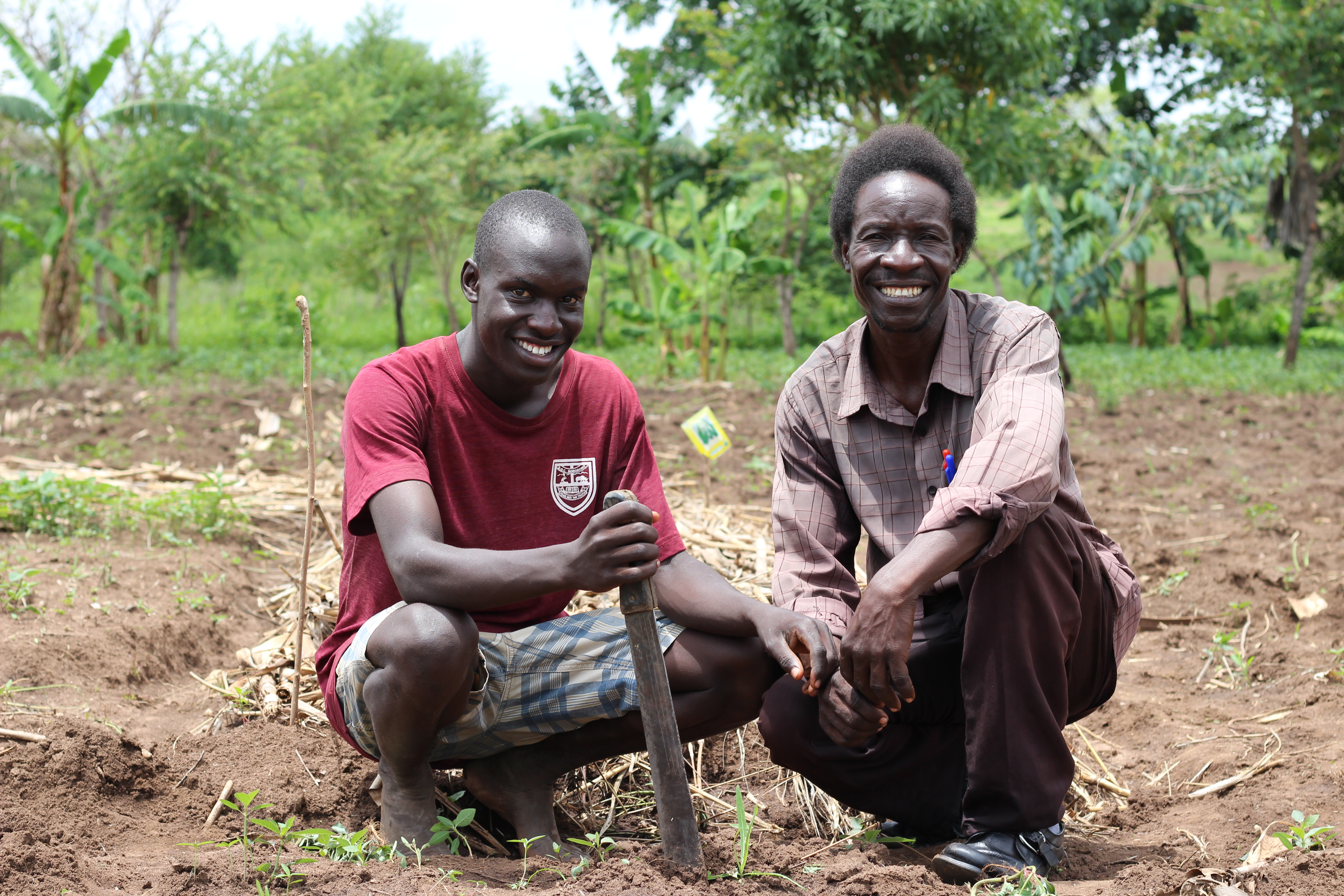 Two farmers sitting in a field.