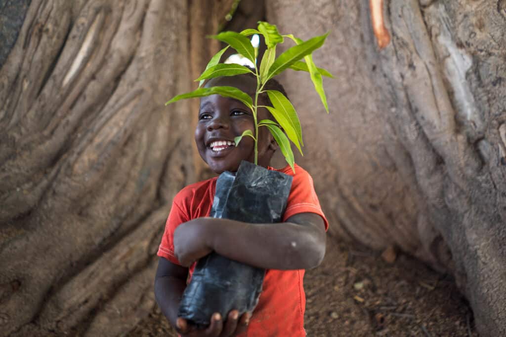 kid smiling with a tree sac