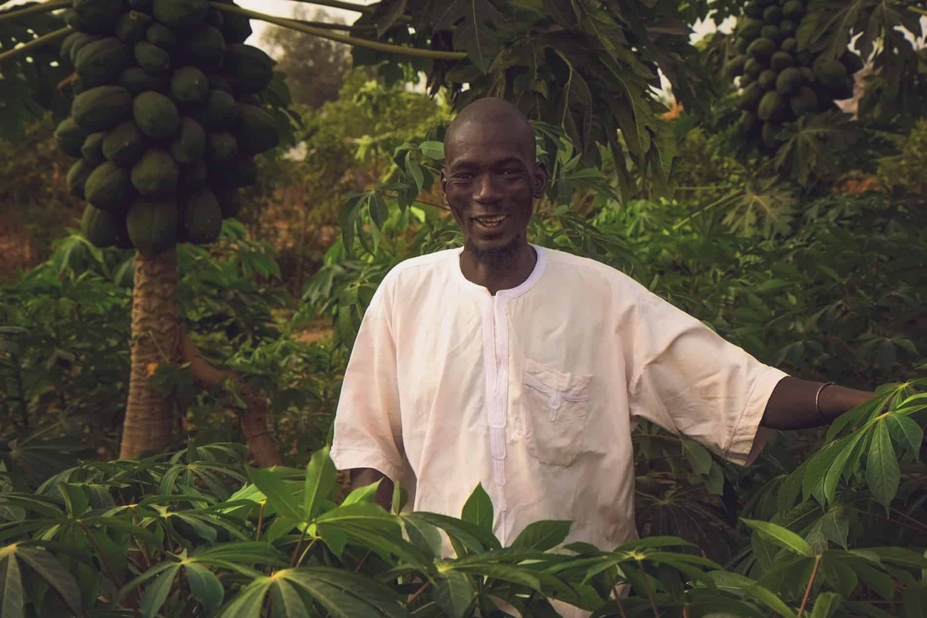 man standing in forest garden smiling