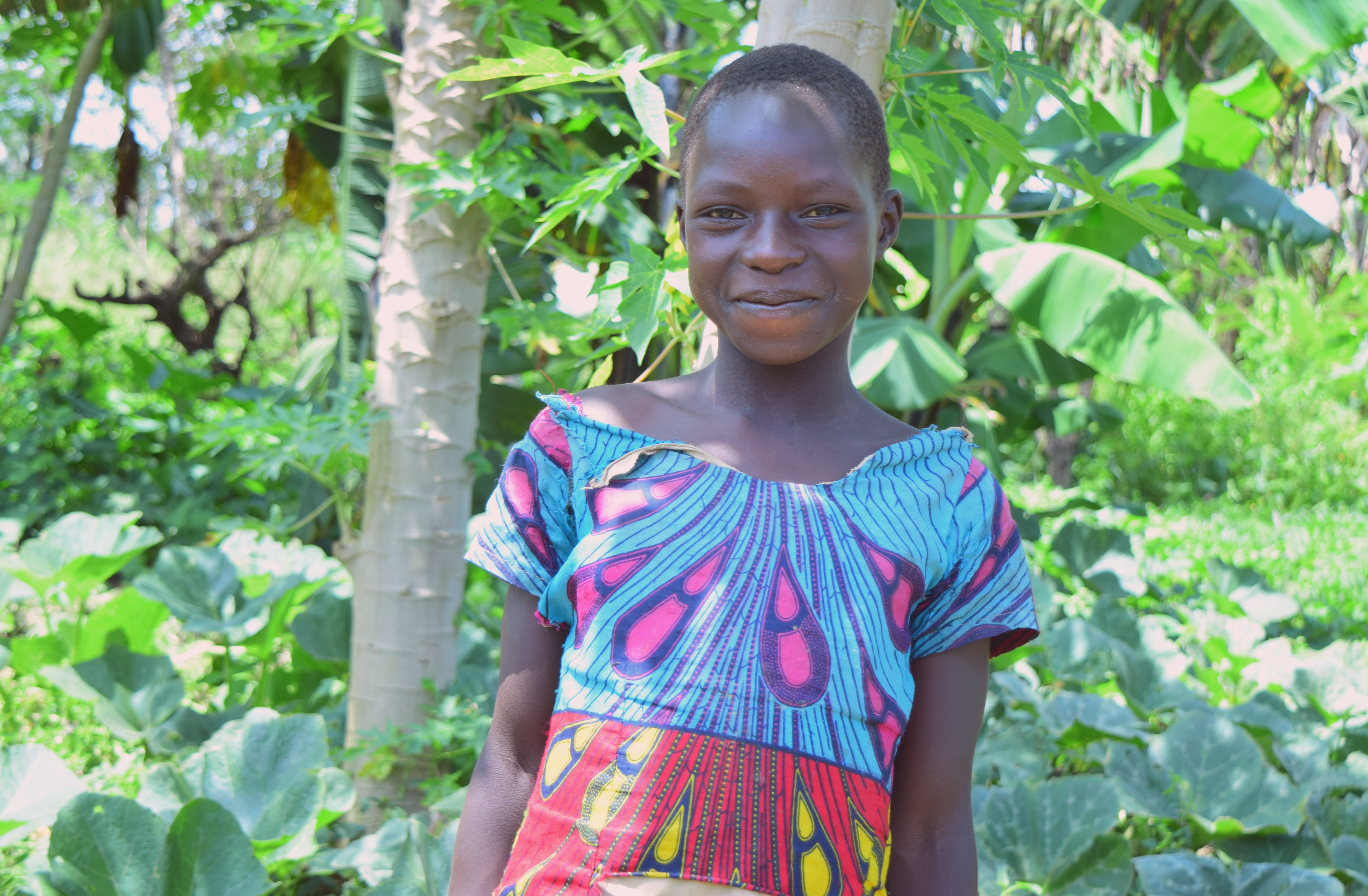 Young girl standing in a thriving Forest Garden.
